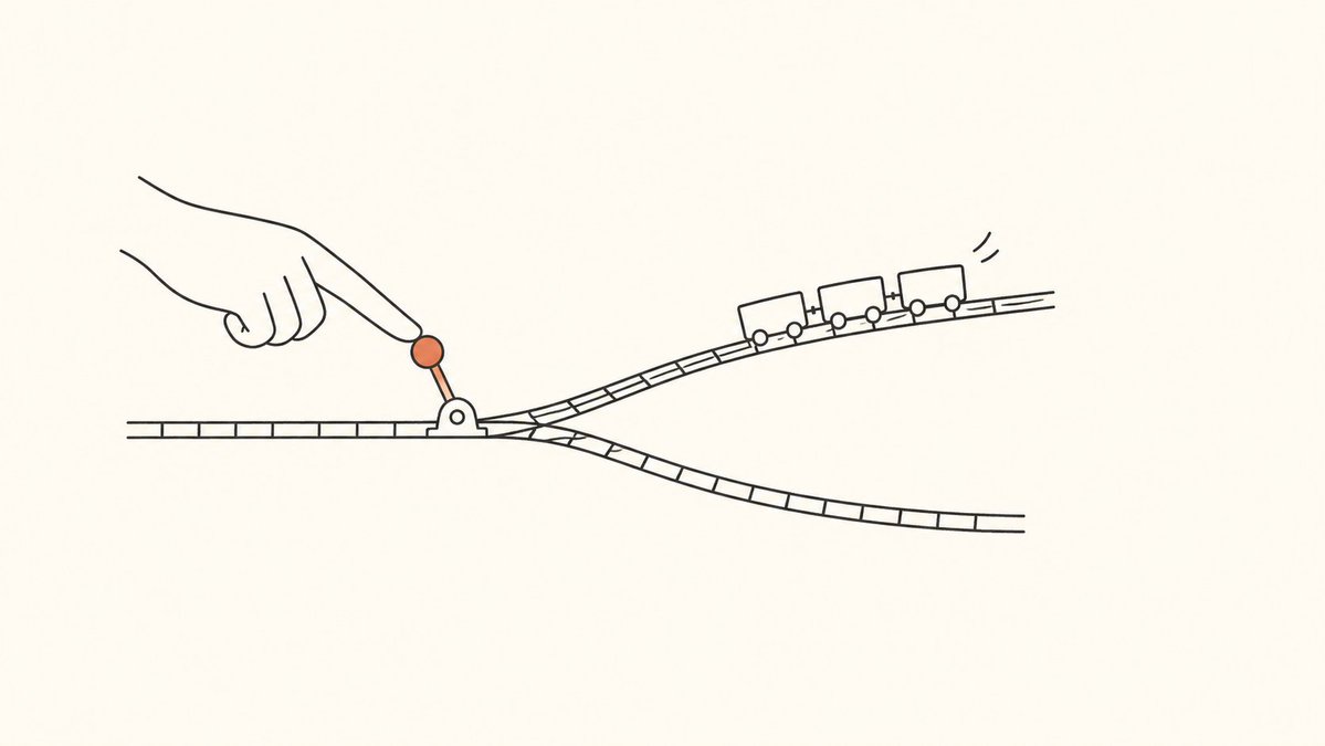 A hand moves an orange railway switch as a train approaches a fork.