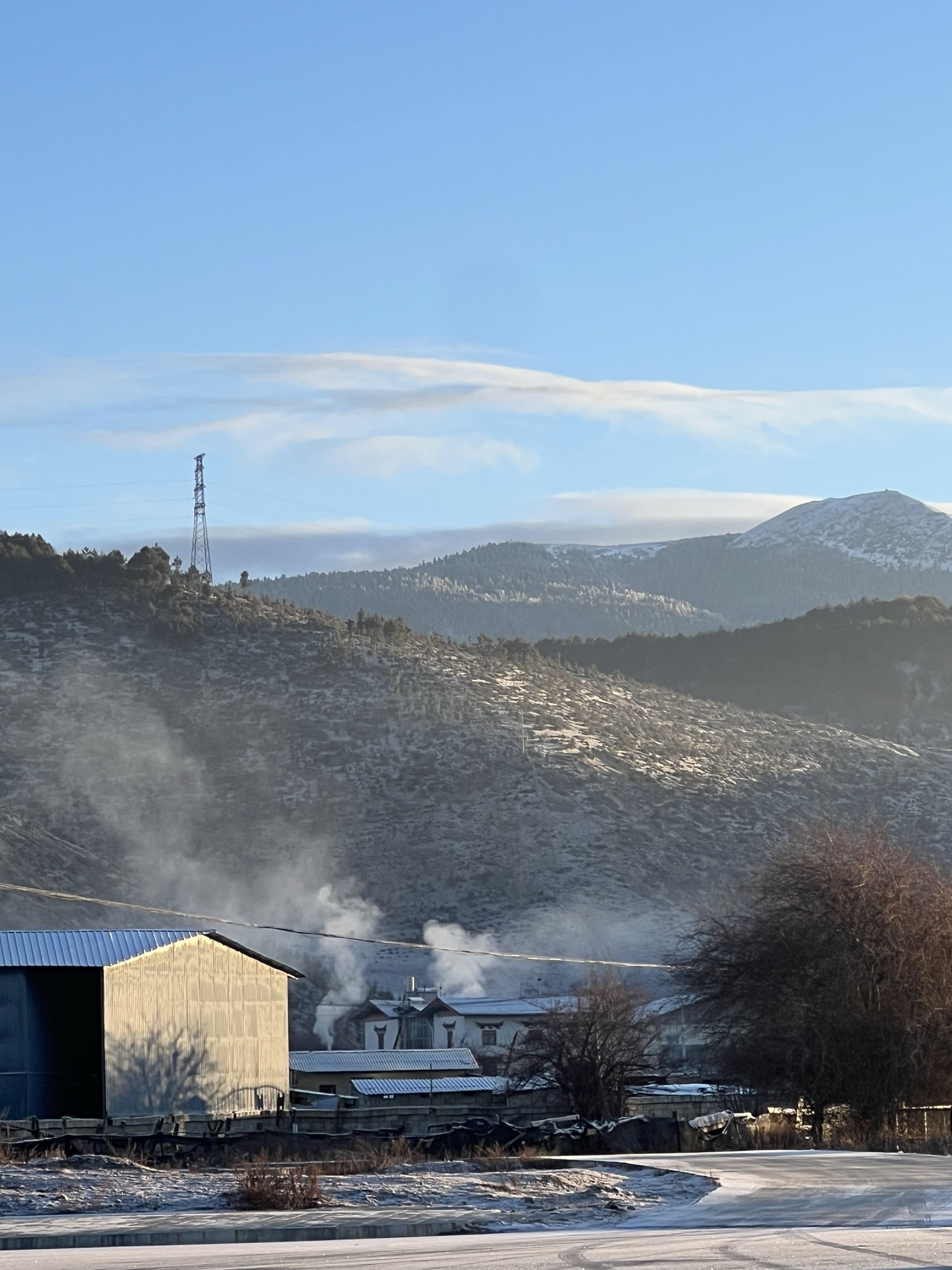 Quiet winter morning in a mountain village with mist and snow