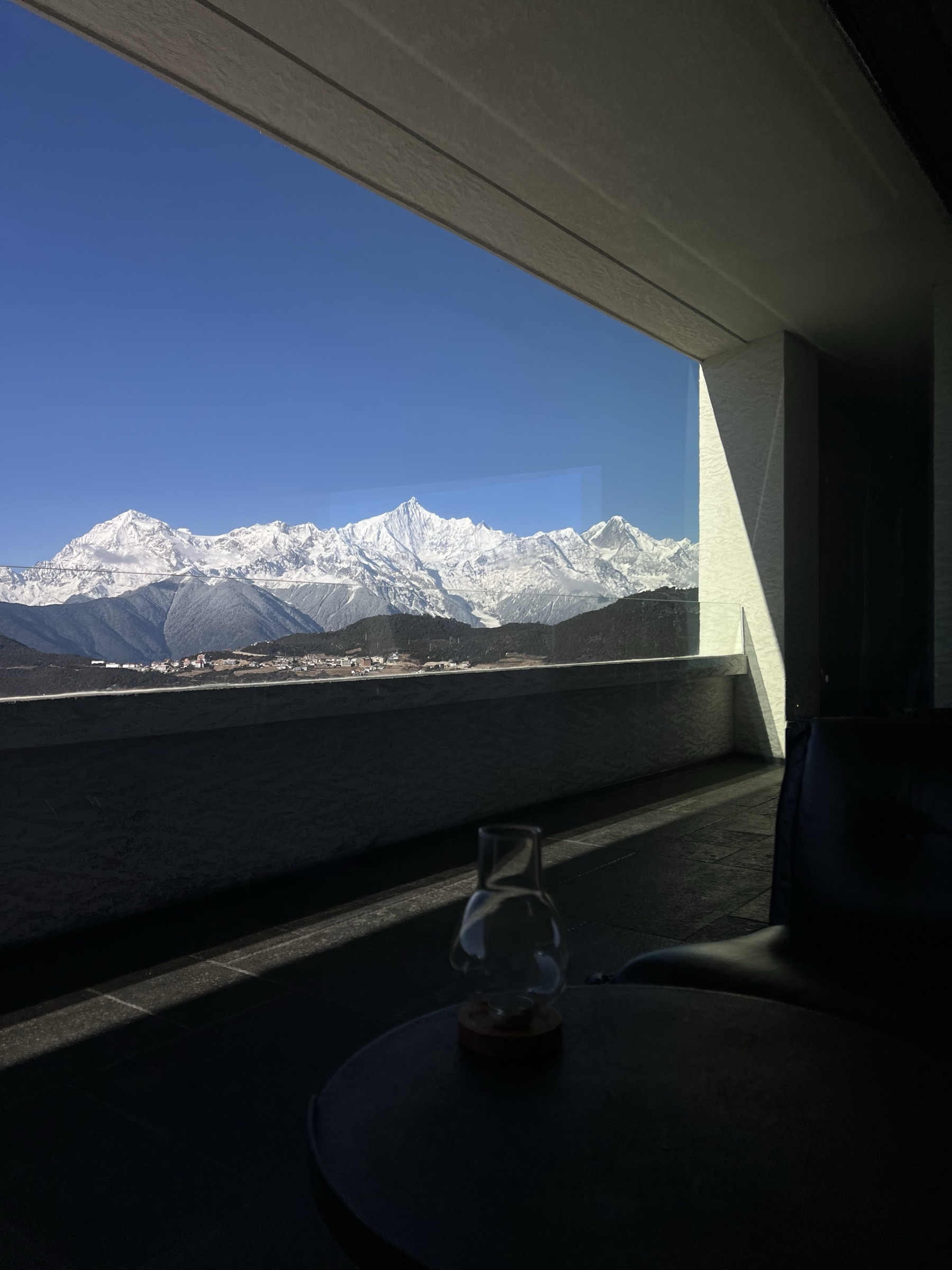Snow mountain panorama framed through a window with a glass carafe