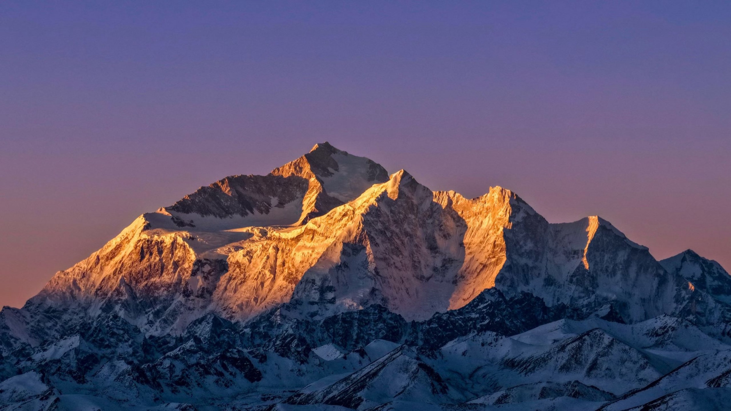 Snow peak glowing gold against a purple twilight sky