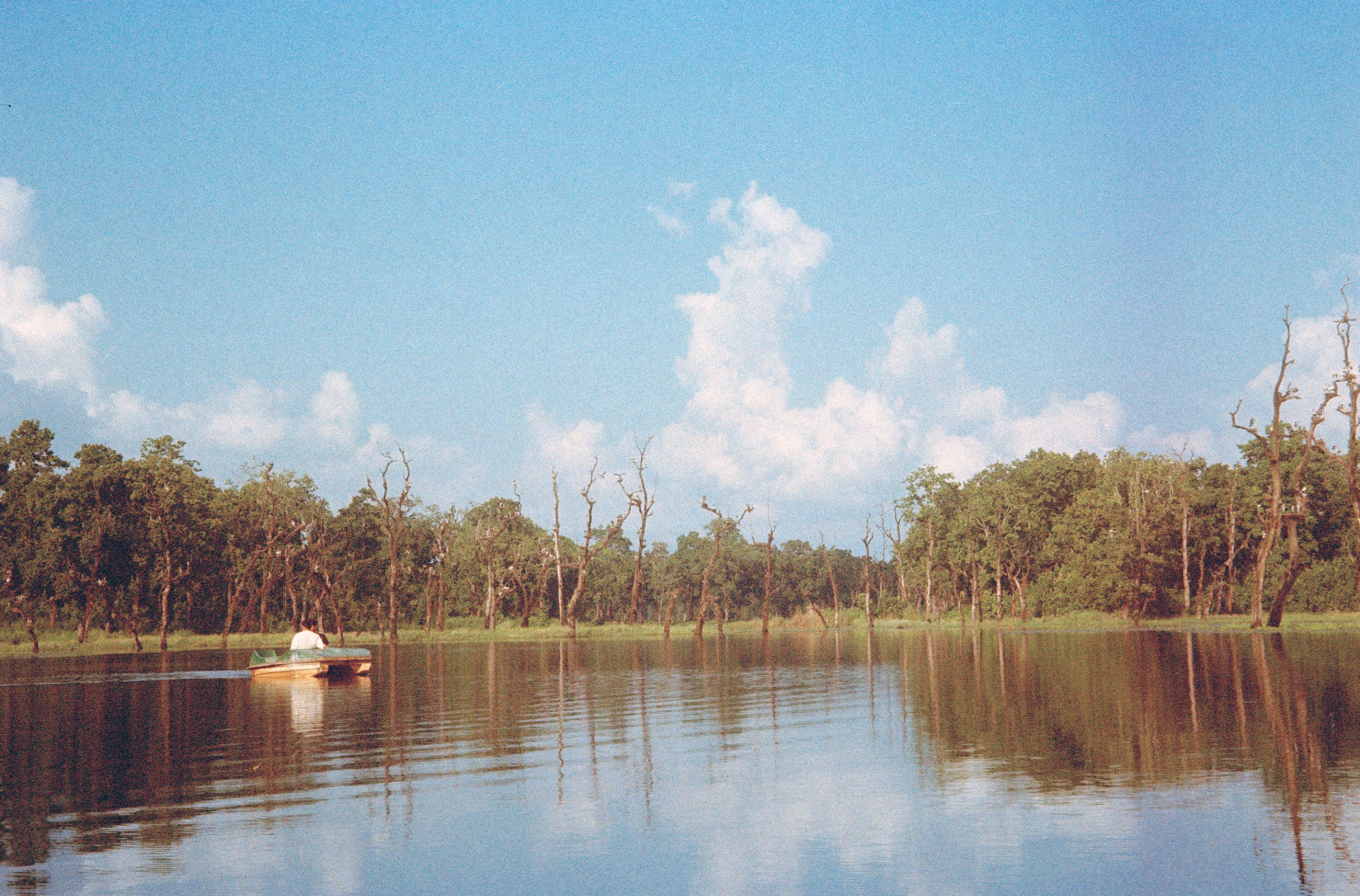 Tranquil lake with a small boat and trees reflecting on the water
